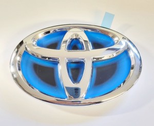 ZNACZEK LOGO ZDERZAK PRZÓD TOYOTA YARIS III 11-14 HYBRYDA 